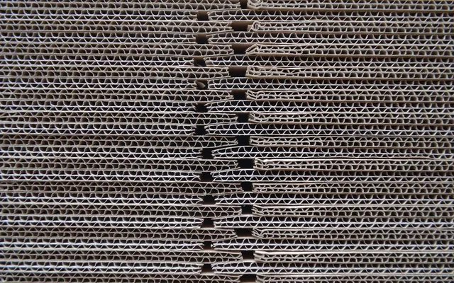 Close-up of stacked corrugated board showing the fluted layers between the liners