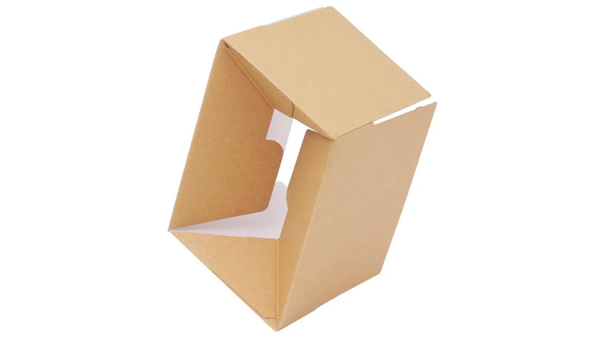 The underside of a kraft corrugated box showing the glued, interlocked panels of a crash-lock base
