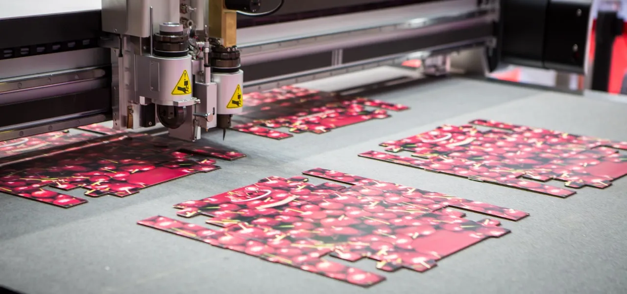 Flat 0427 mailer blanks printed in full colour being cut out on a digital flatbed cutting table