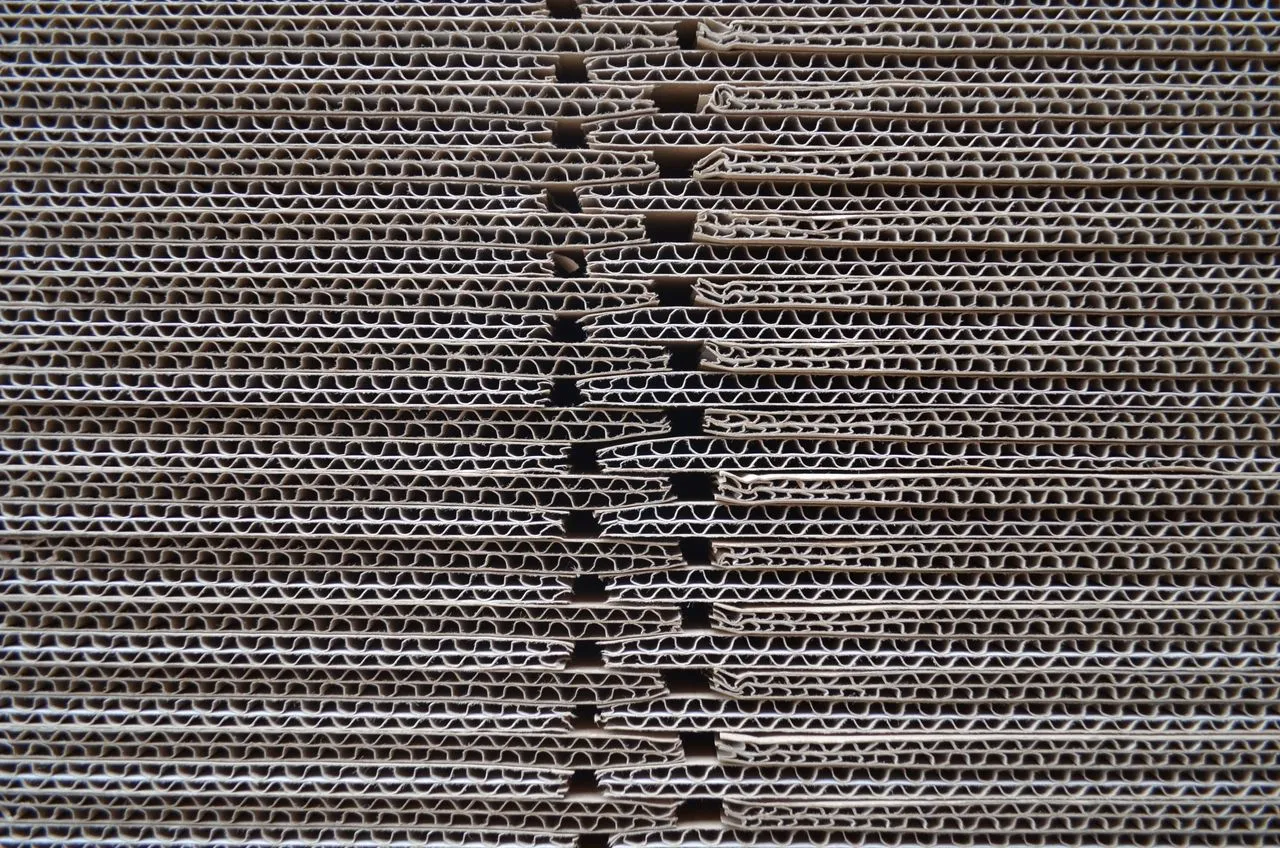 A close-up of stacked corrugated board showing the fluted layers between the liners