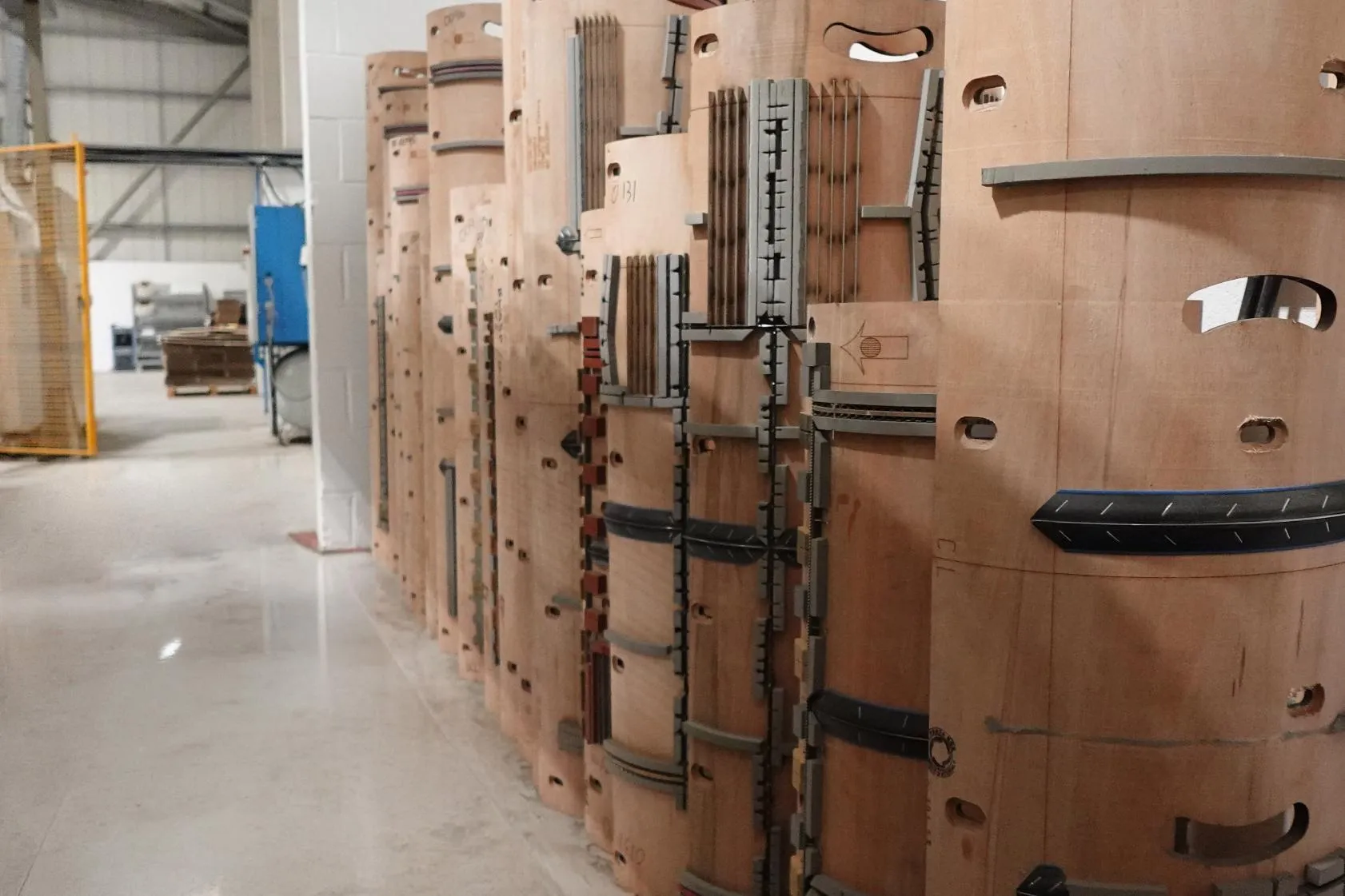 Curved cutting formes stacked in the die store, with rule set into the plywood