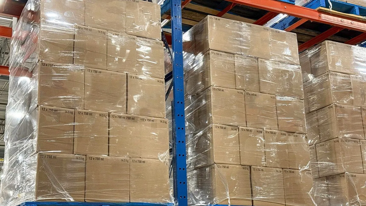 Wrapped pallets of corrugated cases stacked high in warehouse racking