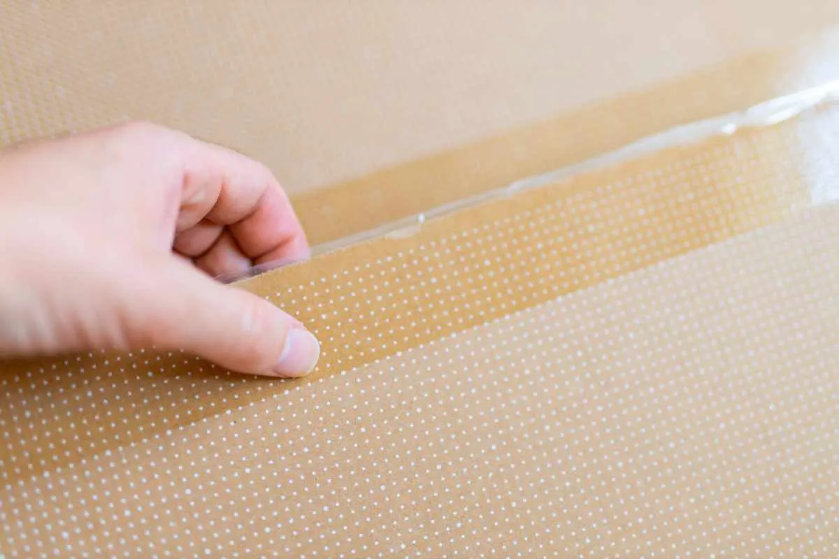 A release liner being peeled back from an adhesive strip
