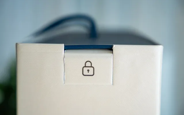 A sealed tab across the lid of a carton, printed with a padlock mark