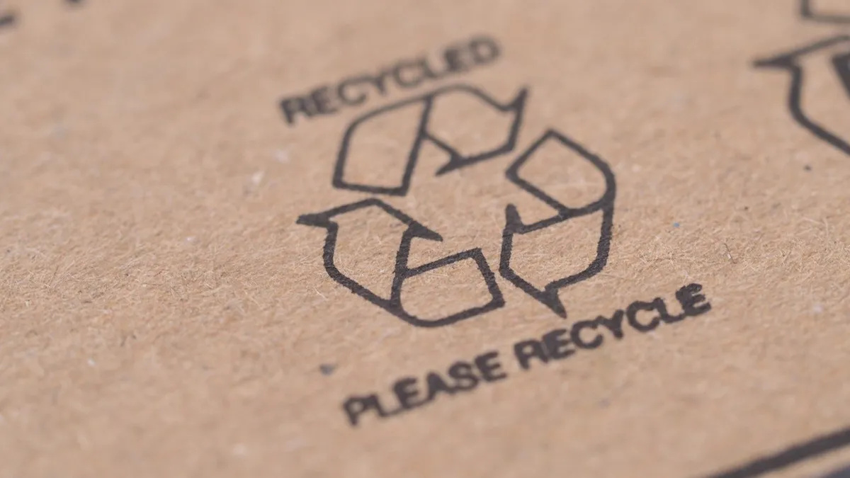 A close-up of a recycling mark printed in black ink on kraft corrugated board