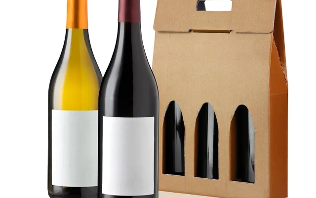 A three-bottle corrugated gift carrier with die-cut windows and a hand hole, beside two unlabelled wine bottles