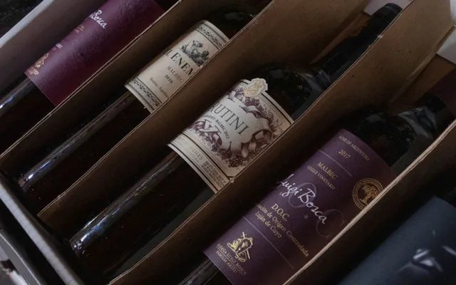 Wine bottles lying in the corrugated divider slots of a shipping case